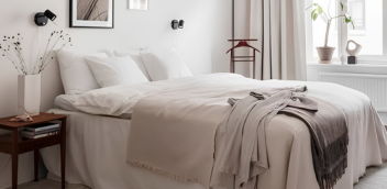 Cleaner making a bed in a tidy bedroom